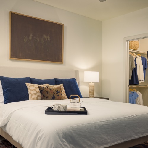 spacious bedroom with nightstands and walk-in closet
